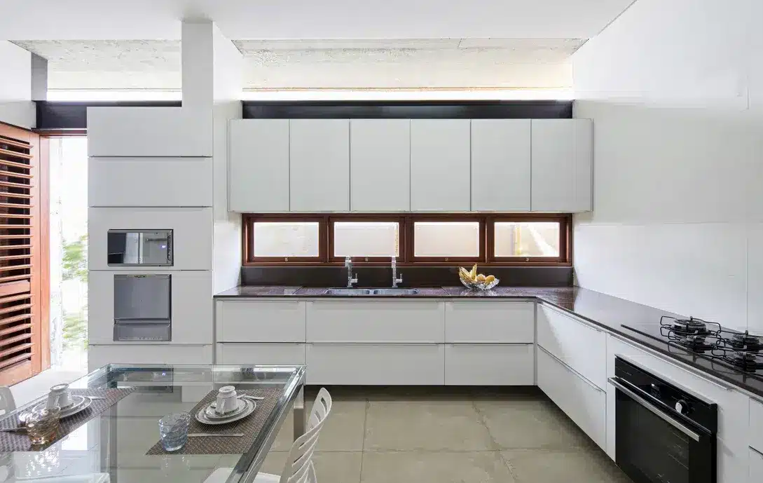 Cozinha branca com boa iluminação natural. Aspeto clean. Uma boa iluminação dá ao ambiente uma sensação de aconchego (Projeto: Martins Lucena Arquitetos)