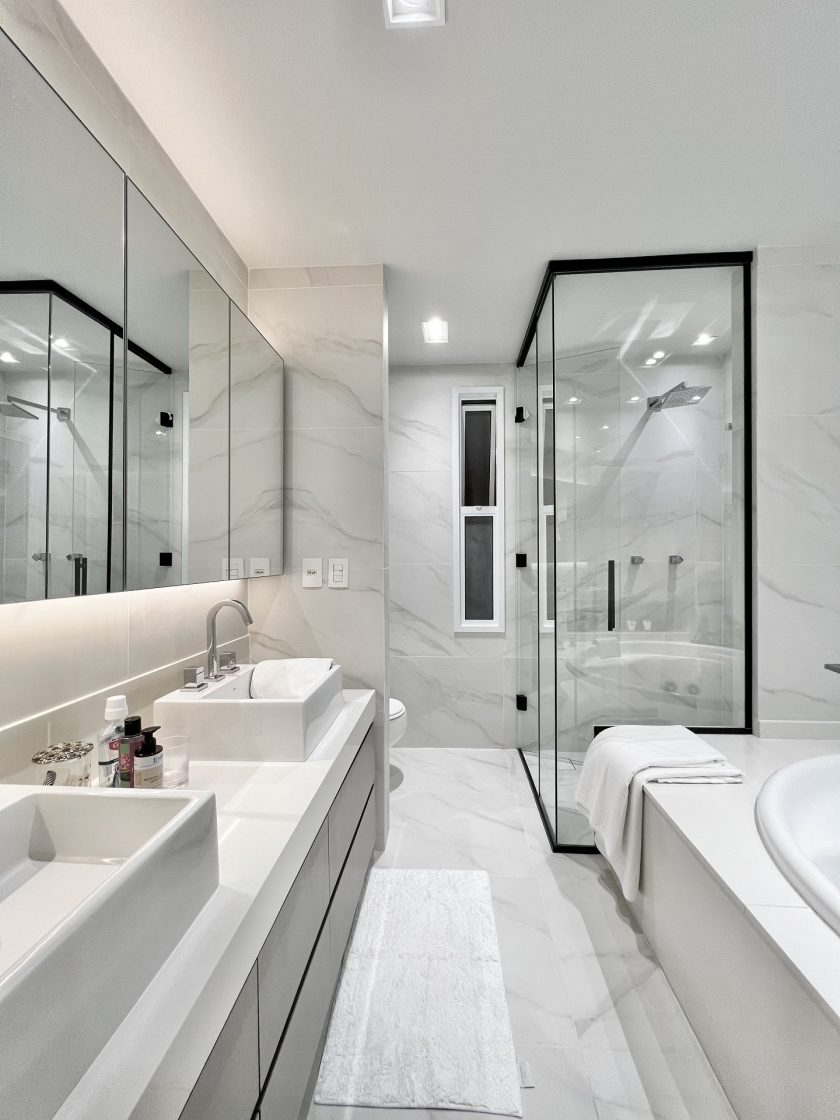 Banheiro de casal com revestimento marmorizado no piso e nas paredes, com ar elegante (Projeto: Victor Romansini - Studio Roma)