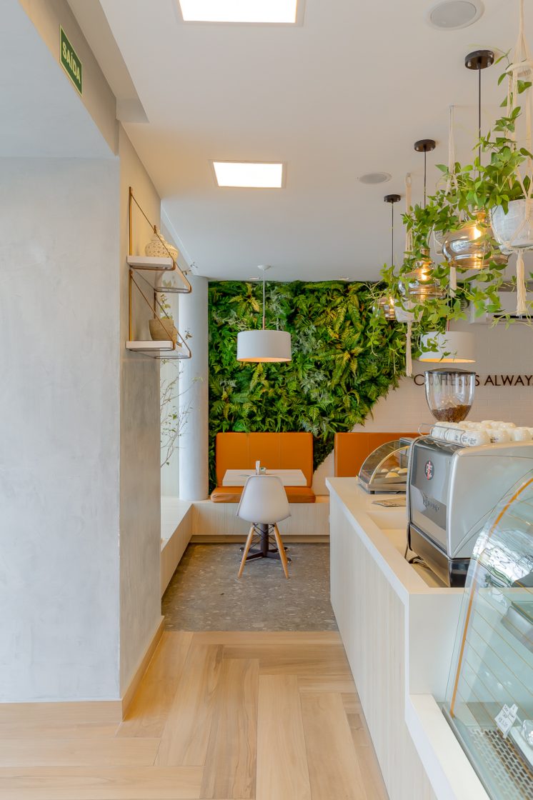 Arquitetura em Restaurantes: Desperte o Desejo de Consumo dos Clientes 8 Plantas nas paredes deixam o ambiente mais aconchegante, como nesta cafeteria que criou uma espécie de jardim secreto (Projeto: Archibox Arquitetura)