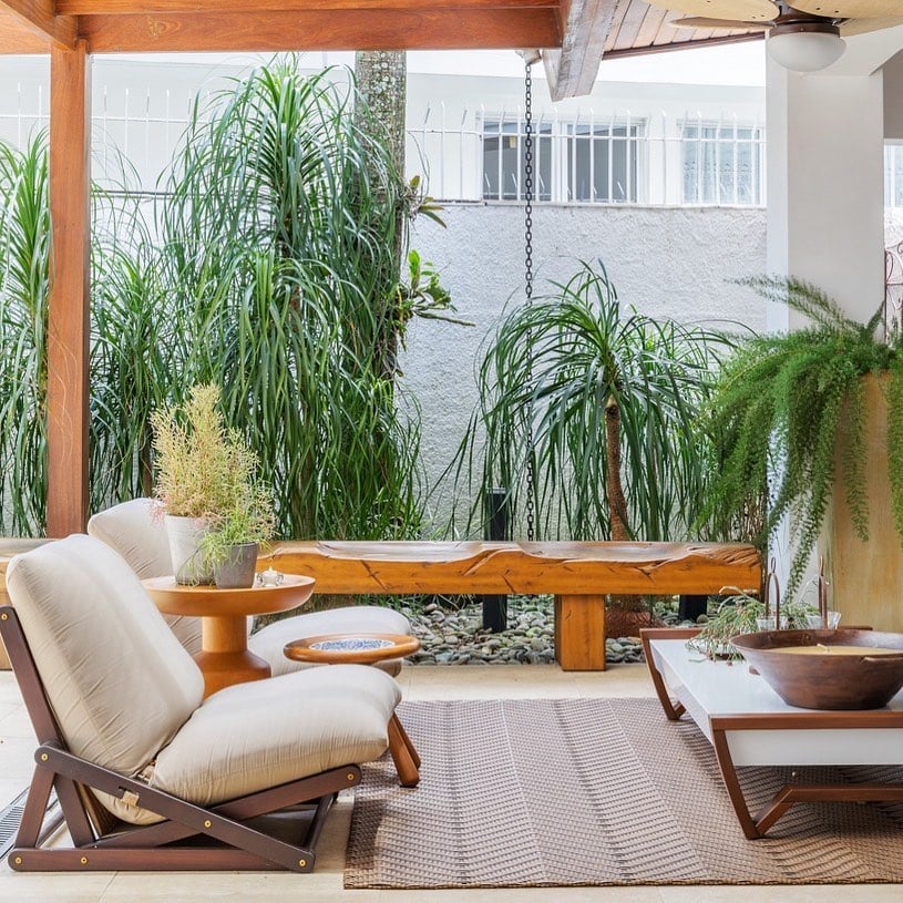 10 Ideias Criativas para Usar Bancos de Madeira na Decoração 8 Banco de madeira com encosto em uma varanda de apartamento.