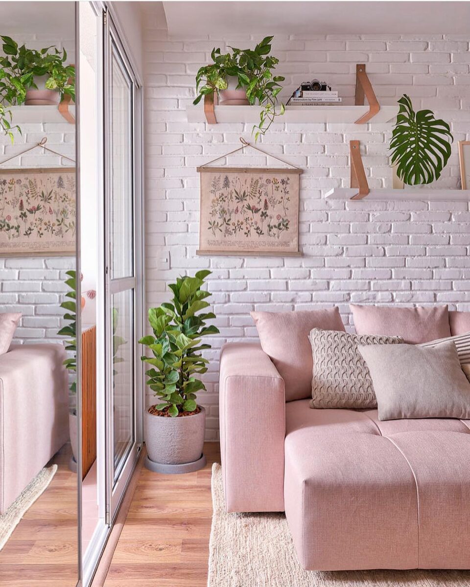 Um sofá rosinha é o destaque na sala decorada.