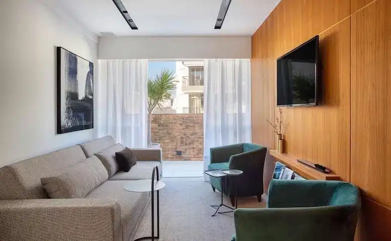 Como otimizar o espaço e decorar uma sala de TV 10 pequena 3 Foto de uma sala de TV decorada com iluminação aconchegante e poltronas confortáveis.