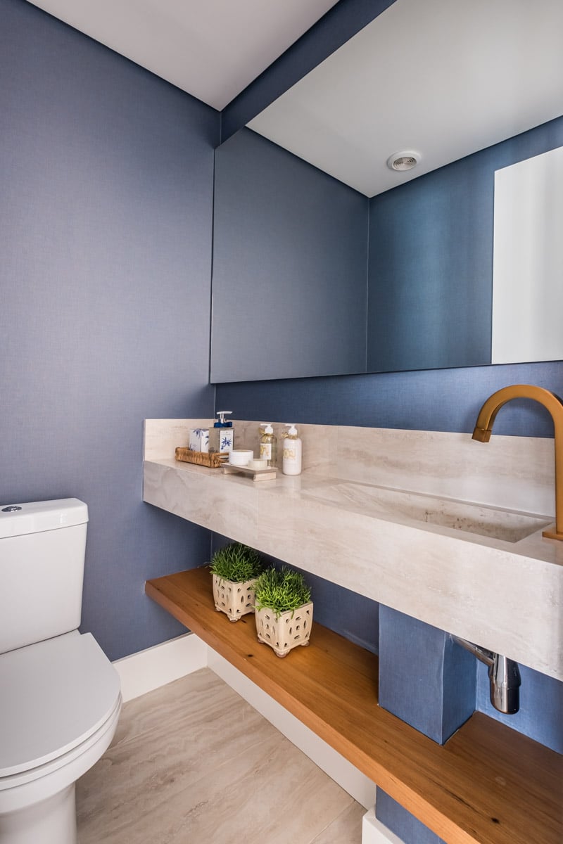 Revitalização e Estilo: Como usar o Porcelanato Travertino na Decoração 10 Lavabo com piso de madeira, paredes azuis e cuba em porcelanato marmorizado