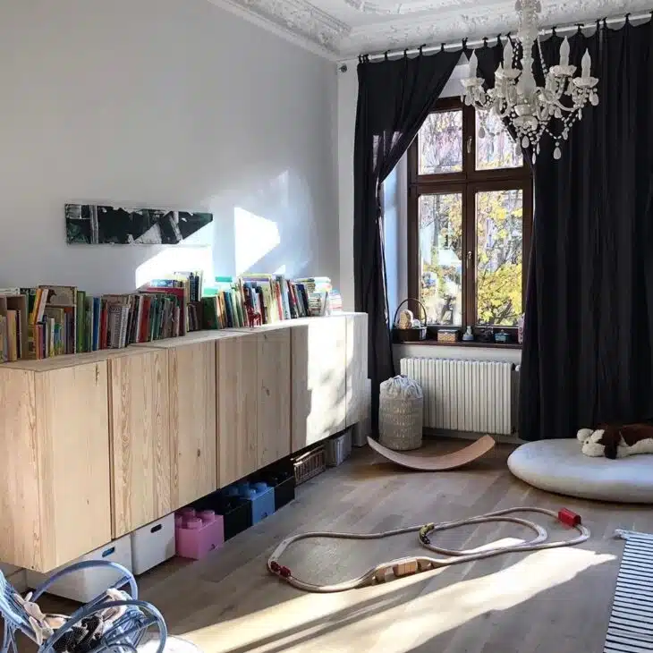 Cortina preta: 10 decorações para um espaço luxuoso e único. 9 Cortina preta em ambiente com lustres, contribuindo para a elegância do espaço.