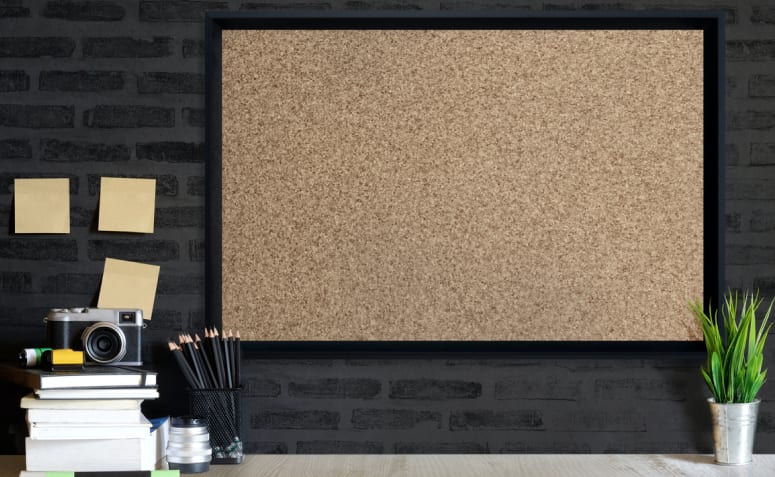 10 Formas Criativas de Decorar e Organizar com Quadro de Cortiça 3 Imagem de um quadro de cortiça com várias fotos e notas coladas.