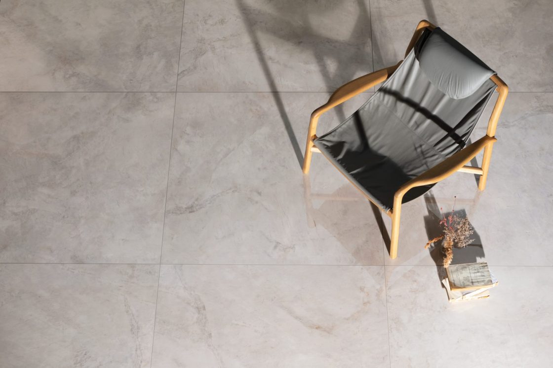 Porcelanato 120x120: fluidez e elegância nos seus projetos 2 Porcelanato 120x120 visto de cima. Há uma cadeira cinza sobre ele