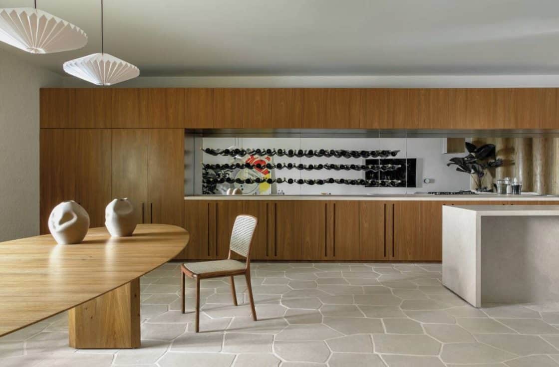 Sala de jantar com grande aparador em madeira, piso e balcão em pedra