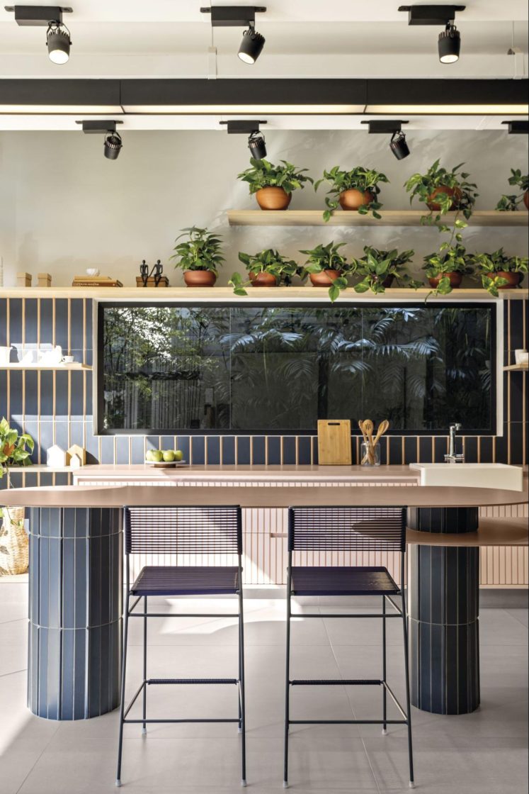 Para a cozinha da Portobello Shop Pacaembu, a Doma Arquitetura criou uma solução leve para a ilha, com colunas e tampo de espessura slim com forma arredondada.