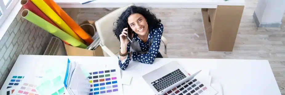 Profissional de Design de Interiores trabalhando com notebook e amostras de cores