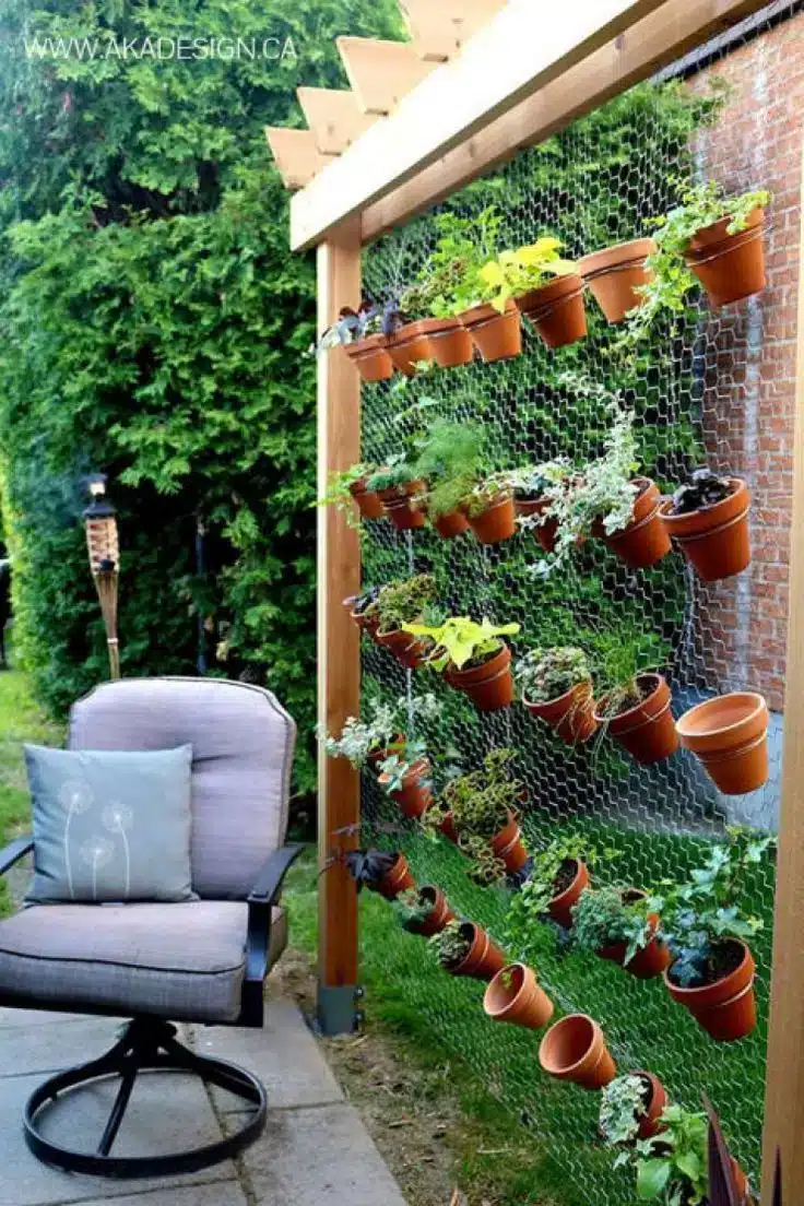 Paredes Verdes: A Solução Perfeita para Ambientes Internos 2 Parede verde feita com tela de aço, servindo como suporte para vasos de plantas.