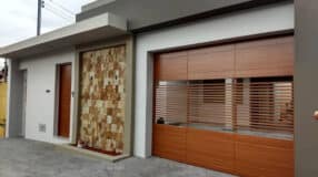 Coberturas de garagem: 10 inspirações para que também elevam a estética da sua casa. 5 Modelo de portão de madeira, ideal para uma entrada diferenciada.