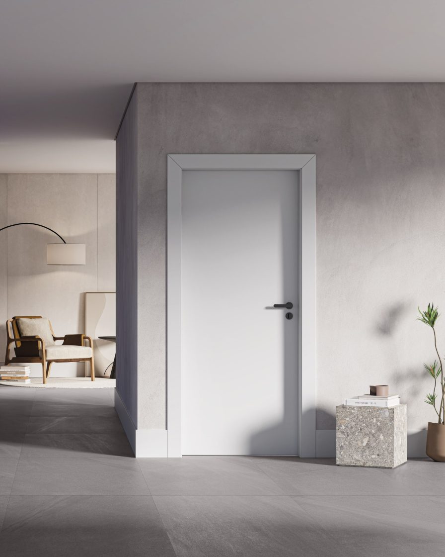 Rodapé de poliestireno: vantagens e aplicações para sua casa 5 Ambiente com ar moderno dá destaque a porta e rodapés brancos feitos em poliestireno. Há também uma mesinha quadrada com livros e uma planta. Ao fundo, há uma sala de estar