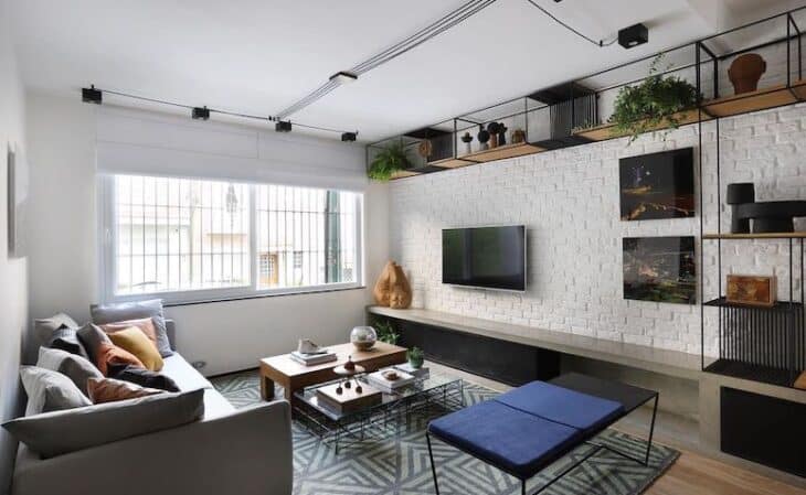 Imagem de uma sala estilo industrial com tijolos aparentes.
