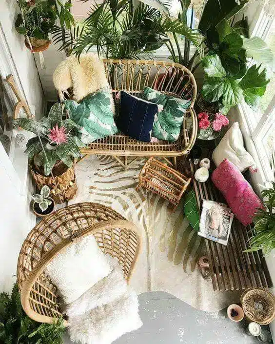 Dicas para Transformar sua Varanda com Vidros para Sacada 5 Varanda decorada com cadeira de balanço, palmeiras e almofadas coloridas, criando um ambiente aconchegante.