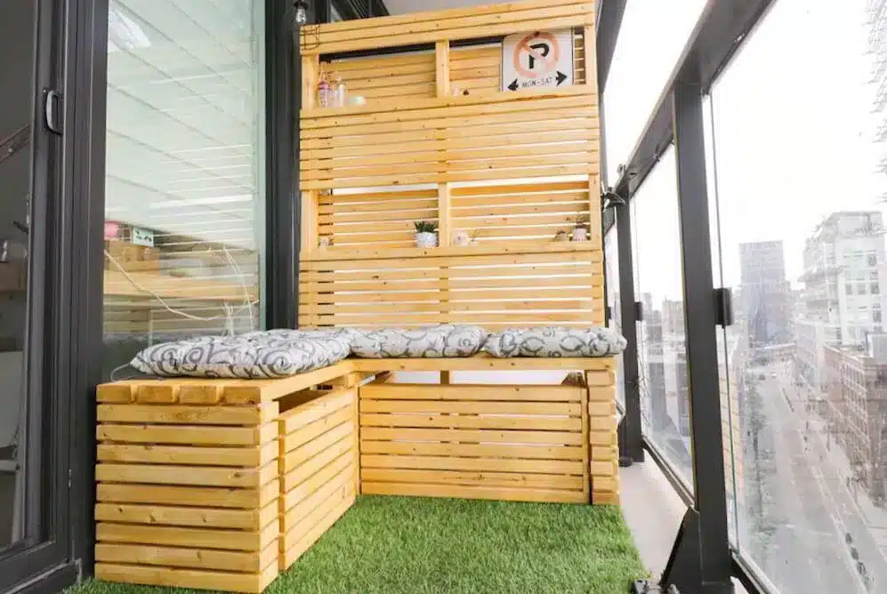Dicas para Transformar sua Varanda com Vidros para Sacada 7 Varanda com móveis de madeira, banco embutido e espaço para plantas, ideal para armazenamento e assentos adicionais.