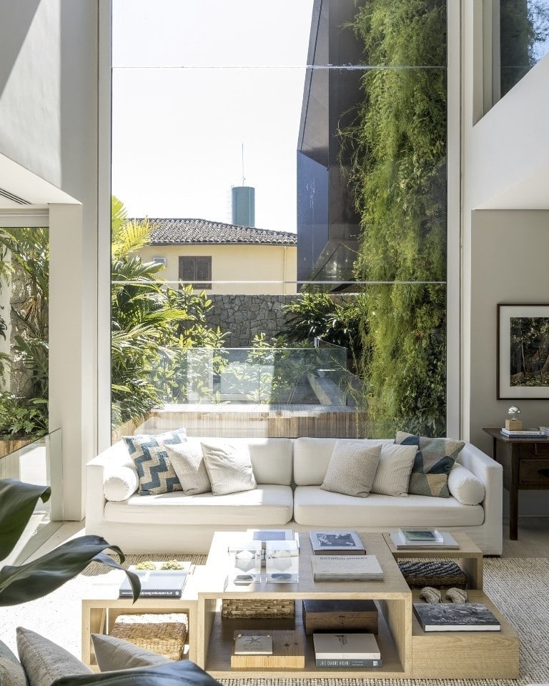 Casas grandes: 80 ideias internas e externas de tirar o fôlego 9 Interior de casa decorado com pé-direito duplo e estante de livros.