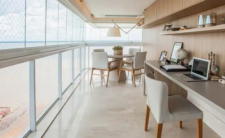 Cortina de vidro em varanda integrada Varanda longa fechada por painéis de vidro com mesa de jantar e bancada de trabalho