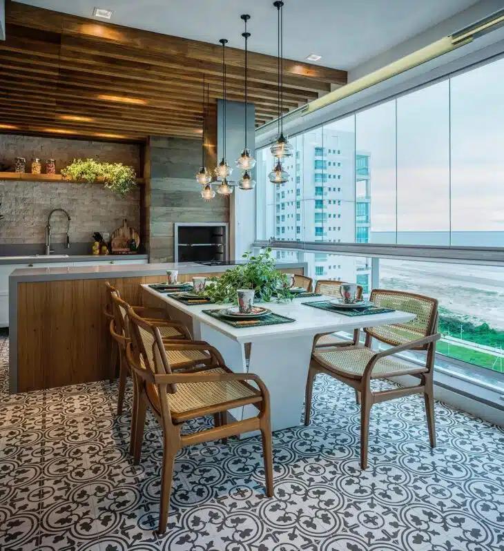 Cortina de vidro em varanda gourmet Varanda gourmet fechada com vidro, mesa de jantar, cozinha e vista para o exterior