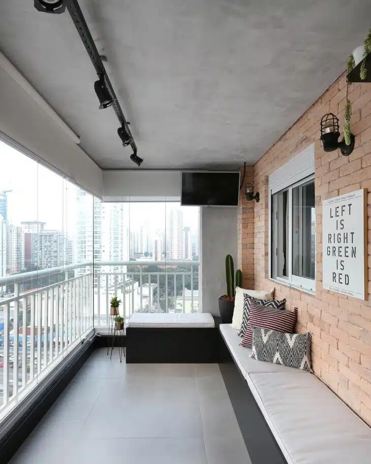 Cortina de vidro em varanda pequena de apartamento Varanda estreita de apartamento fechada com vidro e decorada com banco e iluminação em trilho