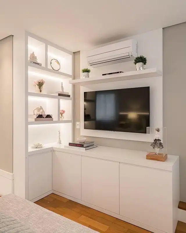Estante branca com TV, nichos e armários em parede da sala
