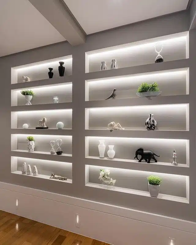 Parede com nichos de gesso iluminados para objetos decorativos