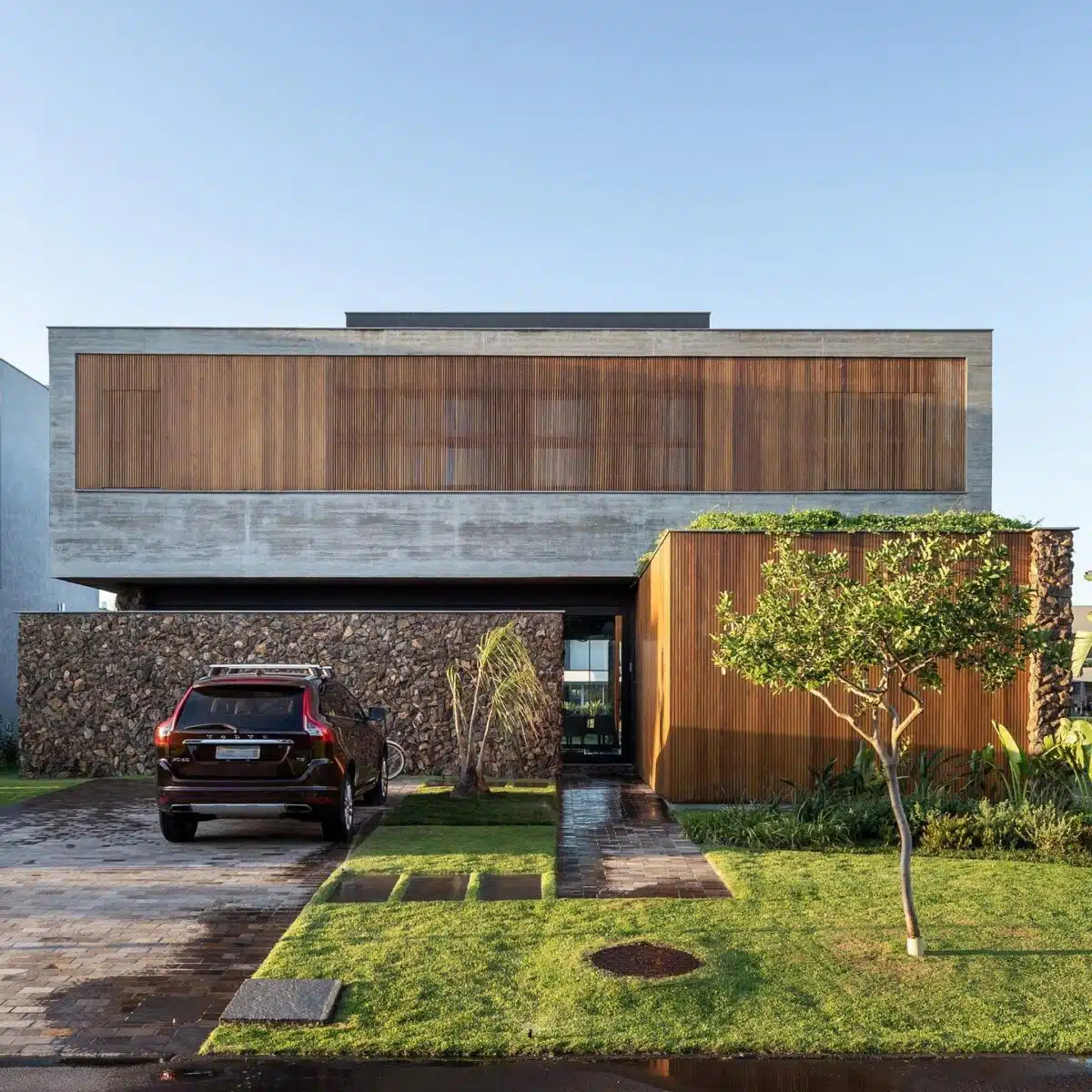 Elementos verticais de madeira em fachada residencial Fachada contemporânea com elementos verticais de madeira no pavimento superior