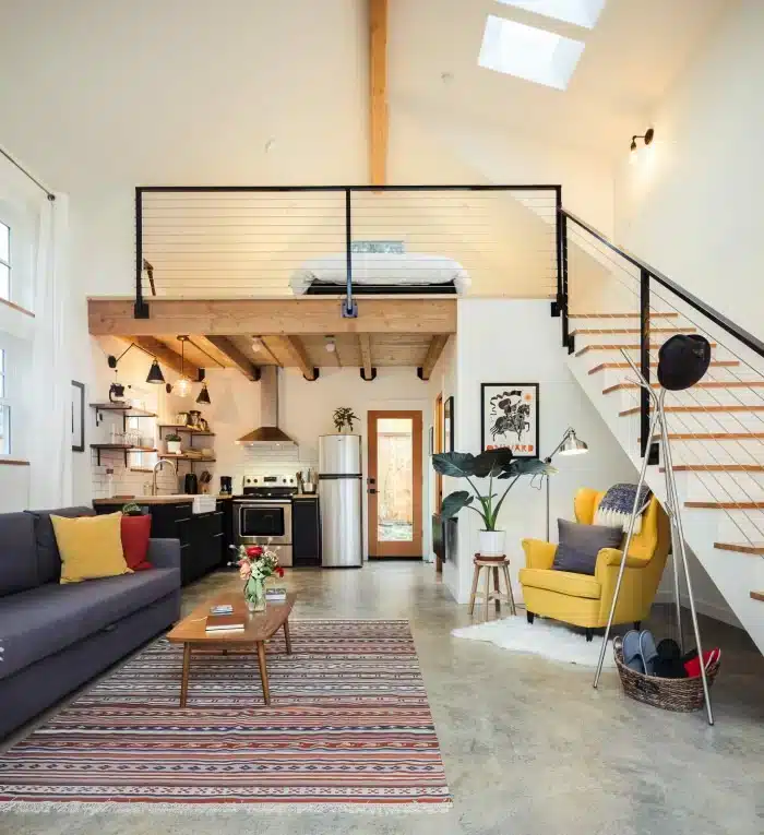 Transformando Kitnet em Loft: Dicas e Inspirações 5 Imagem de um loft com paredes de tijolos expostos e grandes janelas, destacando a iluminação natural.