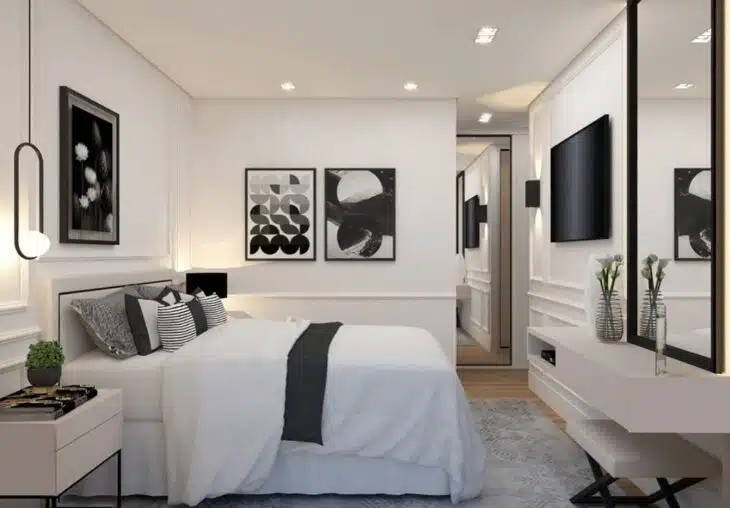Quarto contemporâneo em tons claros com cama, televisão, espelho e circulação ao redor do mobiliário