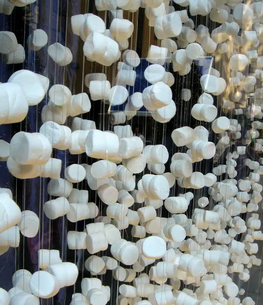 9 Dicas Para Montar uma Vitrine de Natal Encantadora 9 Vitrine de Natal com guirlandas feitas de marshmallow, criando um fundo tridimensional.