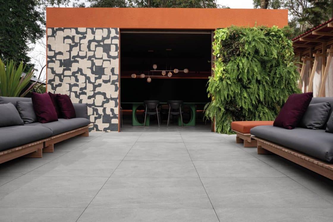 Segredos do Porcelanato Retificado: Transforme seu Ambiente com Estilo! 2 Área externa com sofás, jardim vertical e parede estampada (Projeto: Laura Baltazar) / Foto: Natasha Pirfo