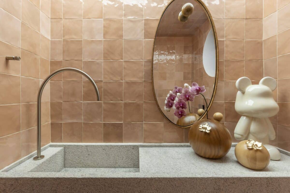 Descubra 6 Revestimentos Cor Pêssego que Estão em Alta e Transforme Seu Espaço! 3 Bancada de banheiro com revestimento cor pêssego ao fundo