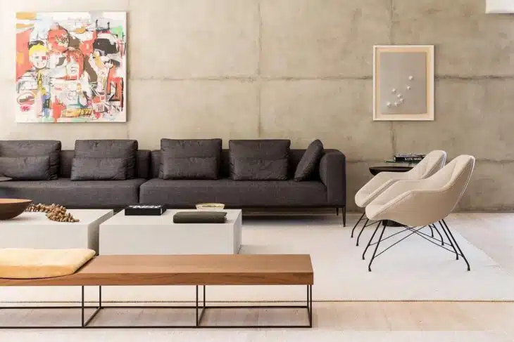 Sofá moderno escuro de desenho linear em sala com poltronas
