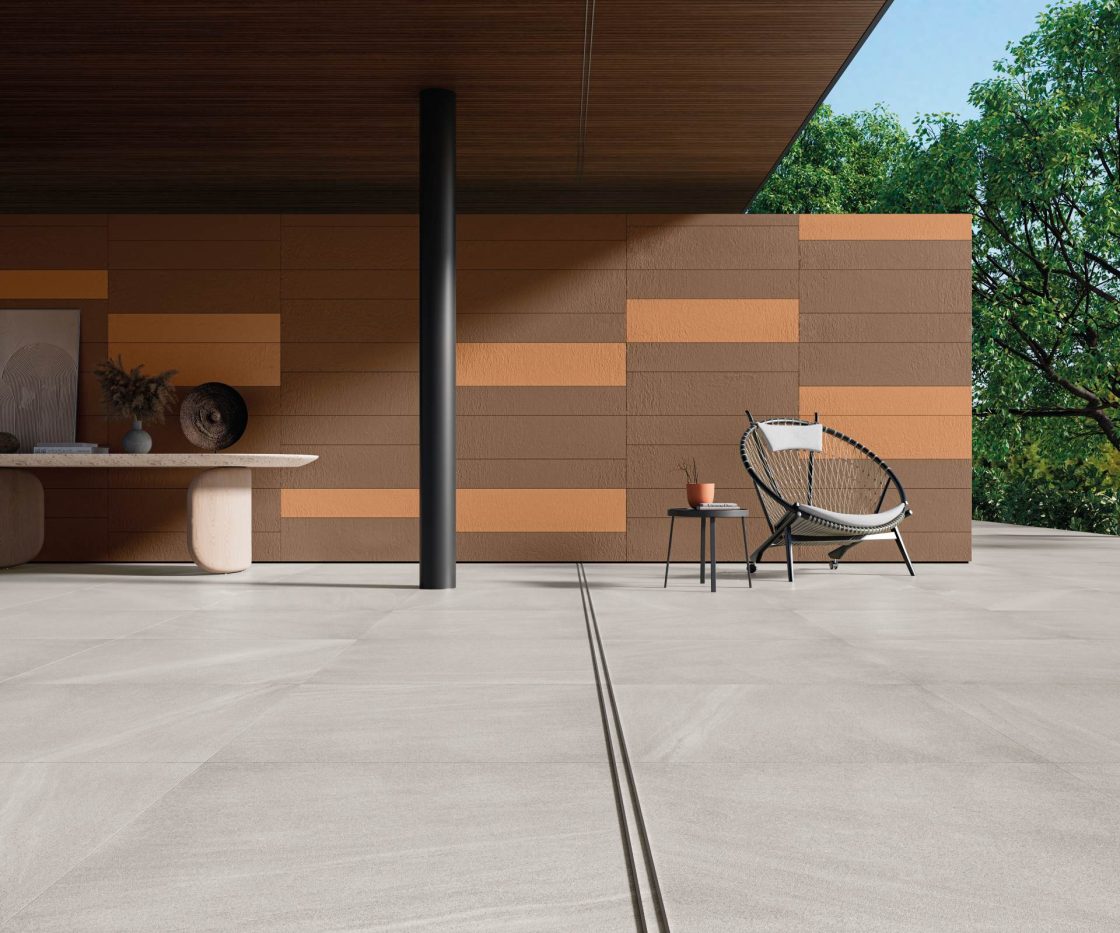Transforme sua Área Externa: Revelamos as Melhores Opções para Dar Vida ao Seu Espaço! 5 Varanda integrada com porcelanato, parede com tons terrosos e vegetação abundante, móveis contemporâneos e design minimalista