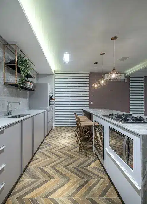 Você sabia que a paginação escama e a espinha de peixe podem transformar seu espaço? Descubra as diferenças e inspirações! 9 Cozinha com um piso em paginação espinha de peixe com cores diferentes em tons cinzas e marrom.