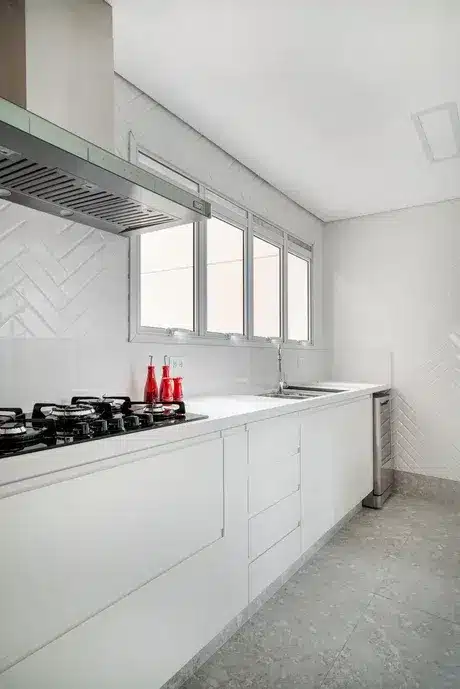Você sabia que a paginação escama e a espinha de peixe podem transformar seu espaço? Descubra as diferenças e inspirações! 10 Cozinha com paredes em revestimento de escama de peixe de cor branca. Móveis brancos.