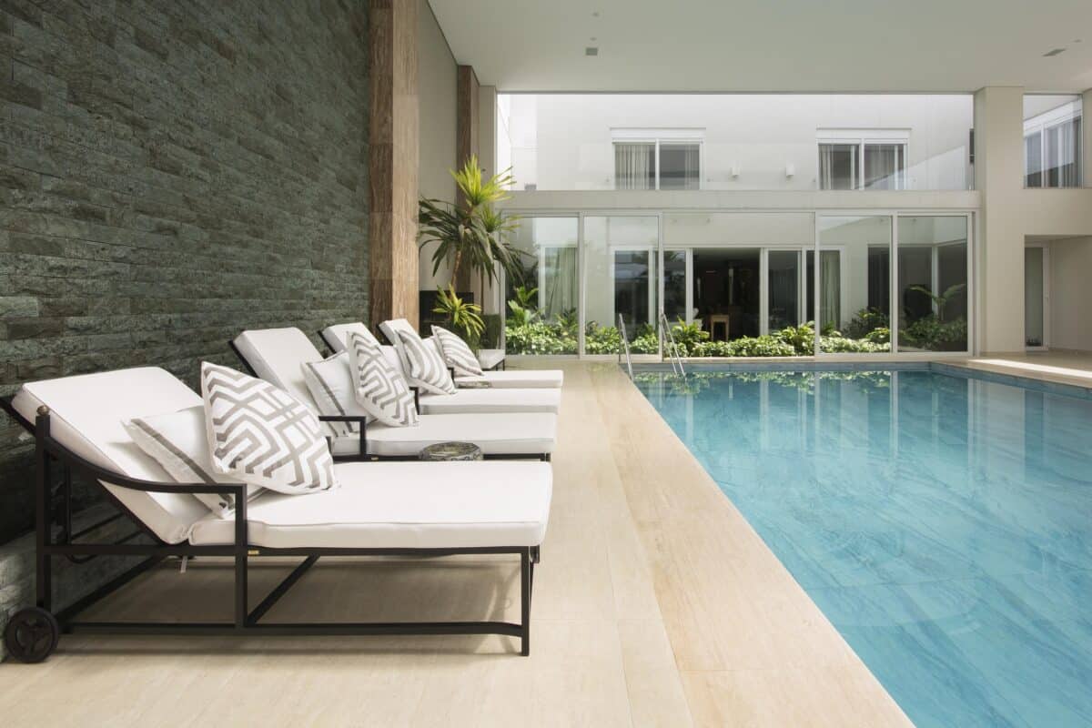 Transforme sua Piscina com Estilo: 6 Tipos de Porcelanato que Impressionam! 5 Porcelanato azul marmorizado leva sofisticação à área de lazer (Projeto: Maria Cristina Abbs da Fonseca e Castro)