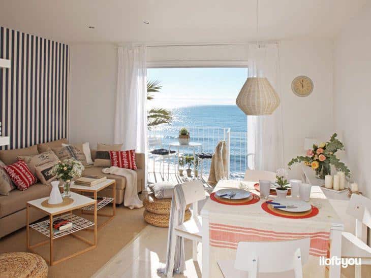 Pequeno apartamento de praia: decoração que inspira e relaxa 3 Foto de um pequeno apartamento de praia decorado, mostrando a sala de estar com vista para o mar.