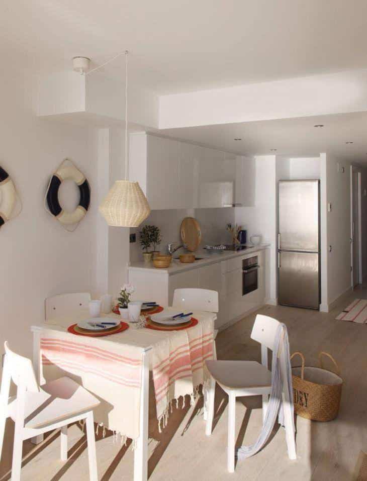 Foto da cozinha do apartamento, com armários brancos e decorativos.