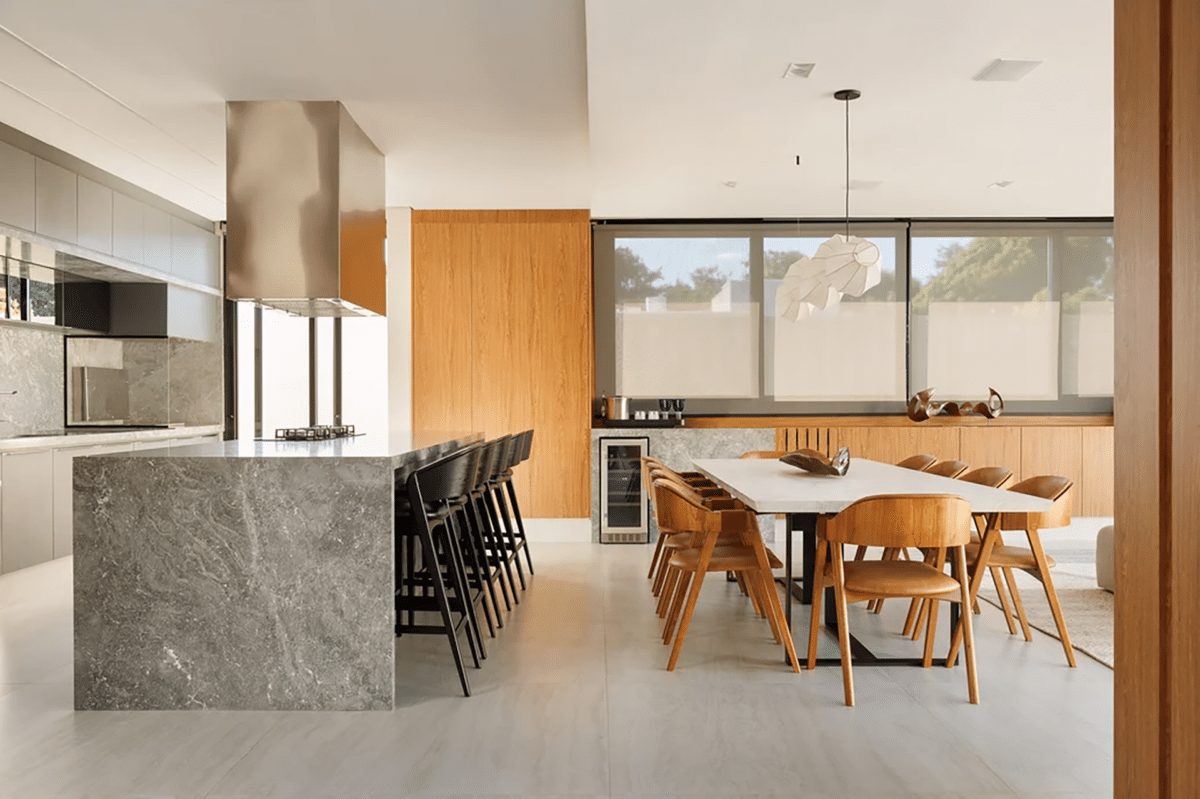 Transforme sua casa em um refúgio acolhedor com piso aquecido: descubra como! 7 Cozinha gourmet ampla e em tons neutros, com destaque para as pedras e a madeira.