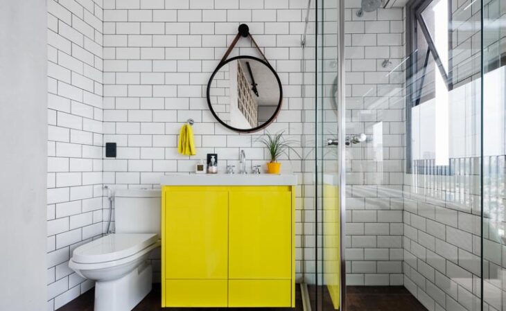 Ideias Criativas para Decorar Sua Casa com Espelhos Redondos 5 No banheiro o espelho é fundamental para a composição. O formato redondo compõe o visual moderno e urbano com os azulejos de metrô e o amarelo em destaque.