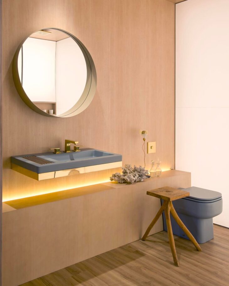 Ideias Criativas para Decorar Sua Casa com Espelhos Redondos 9 A madeira e o espelho trazem uma decoração atemporal para o banheiro. A iluminação complementa a atmosfera aconchegante do ambiente.