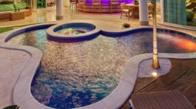 Opções de porcelanato para piscina e orientações de aplicação 9 Foto de uma piscina com hidro que demonstra um espaço relaxante.
