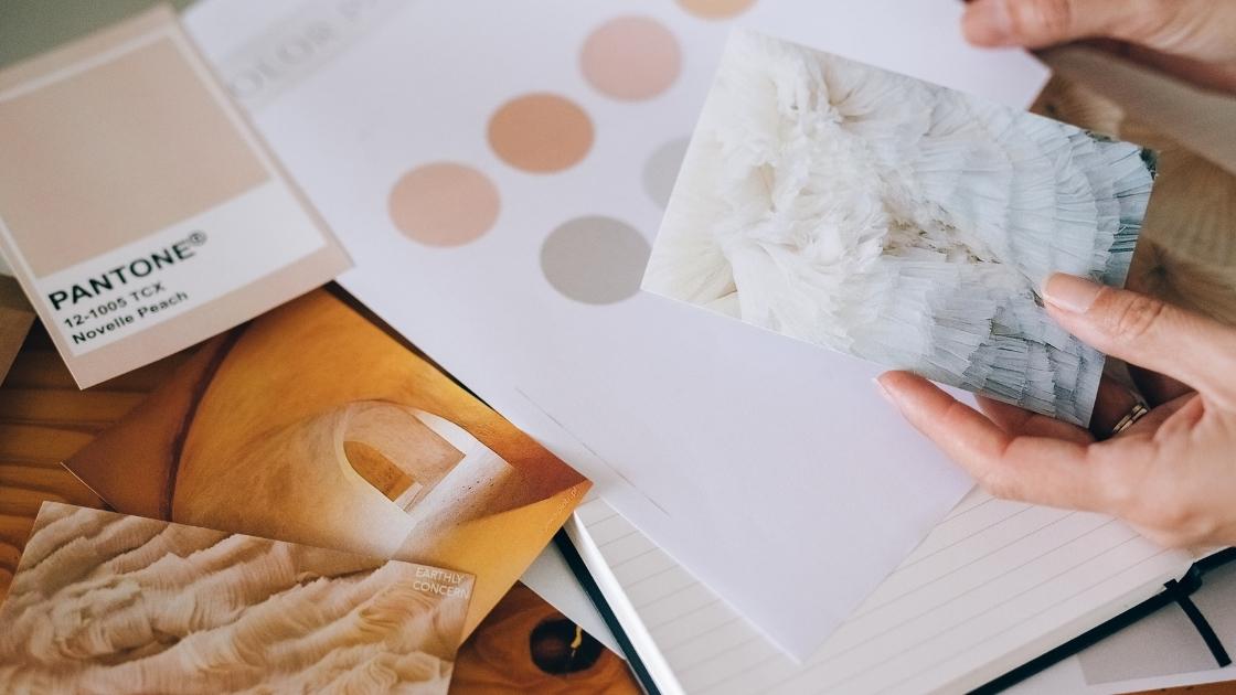 Mãos selecionando referências de cores, texturas e materiais para compor um moodboard de arquitetura
