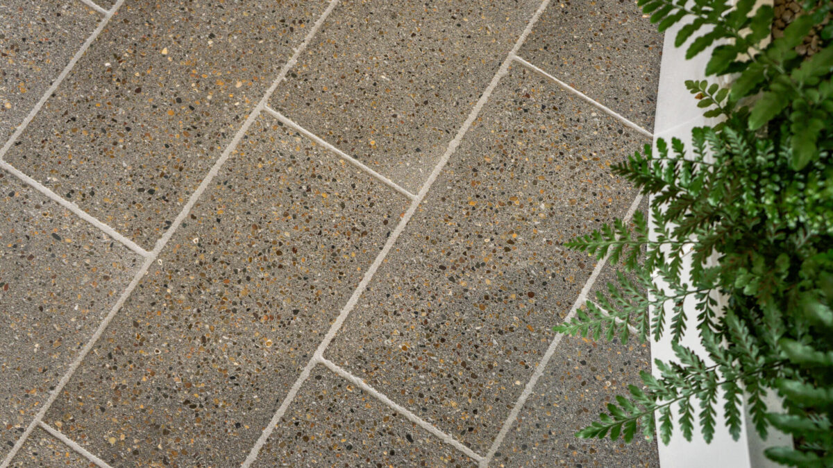 Aplicação real do Mimmik Tile em piso Mimmik Tile instalado como piso em ambiente interno contemporâneo com vegetação