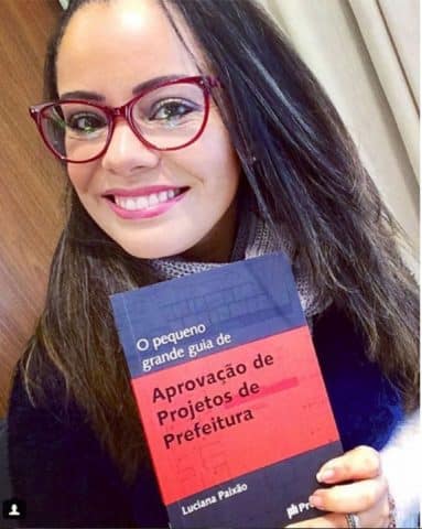 Luciana Paixão segurando o livro "O pequeno grande guia de aprovação de projetos de prefeitura"